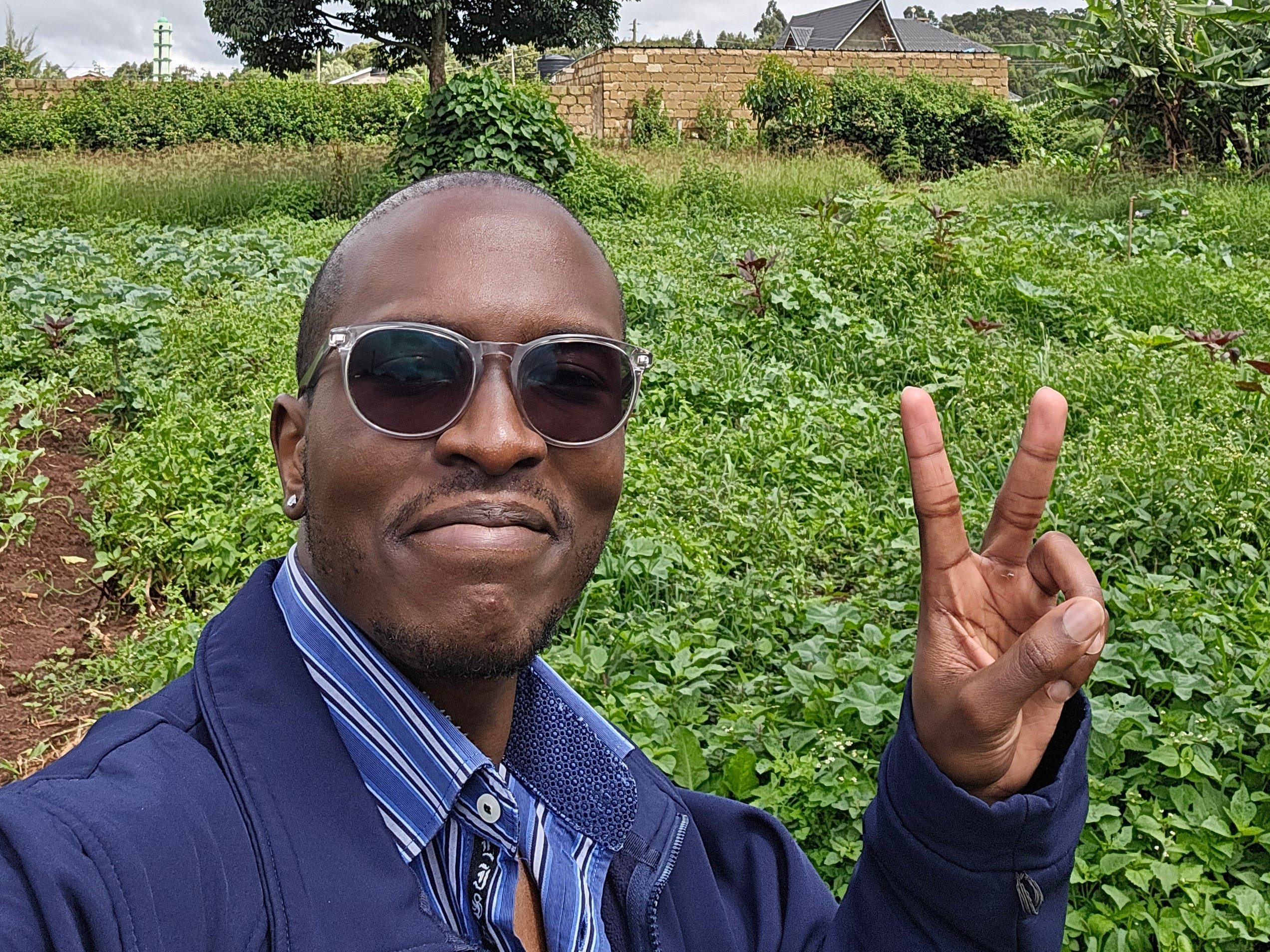 Mwangi Wanjau holding up a peace sign with his hand.