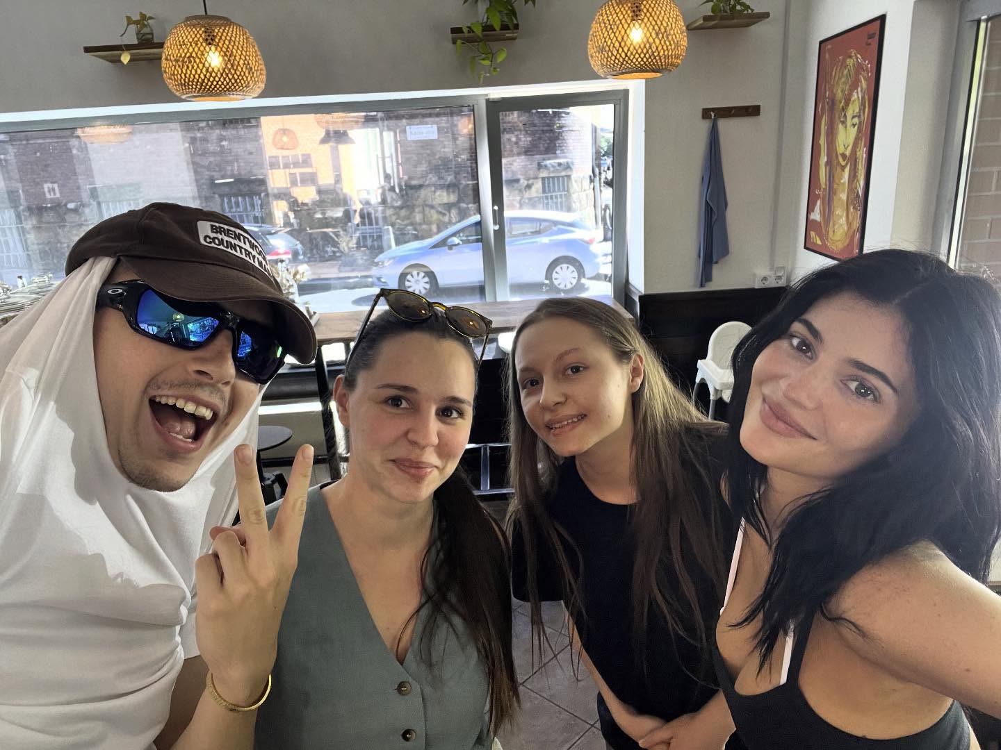 Kylie Jenner and three others pose for a selfie inside a coffee shop.