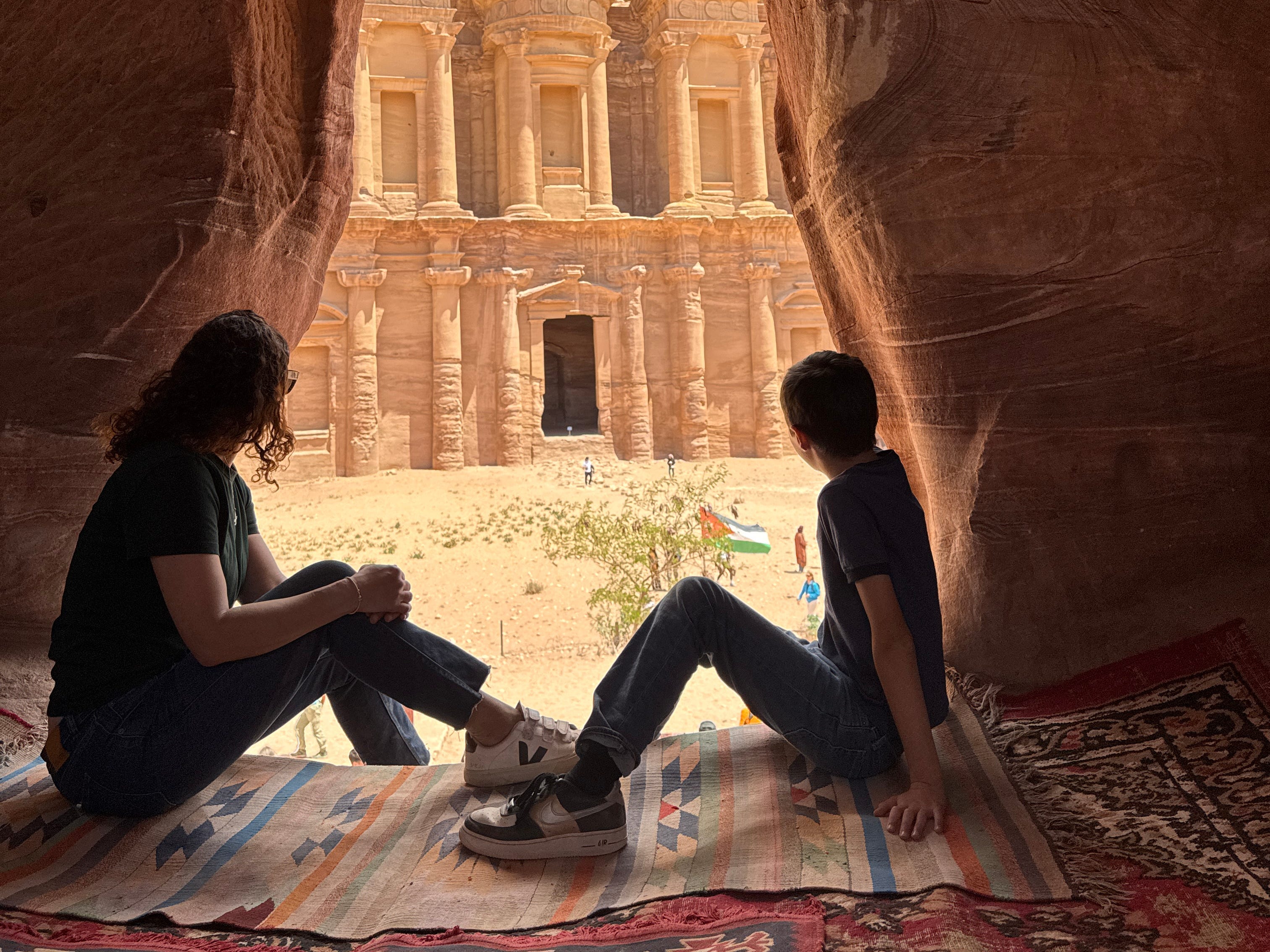 Author Jamie Davis Smith sitting it rock formation with kid