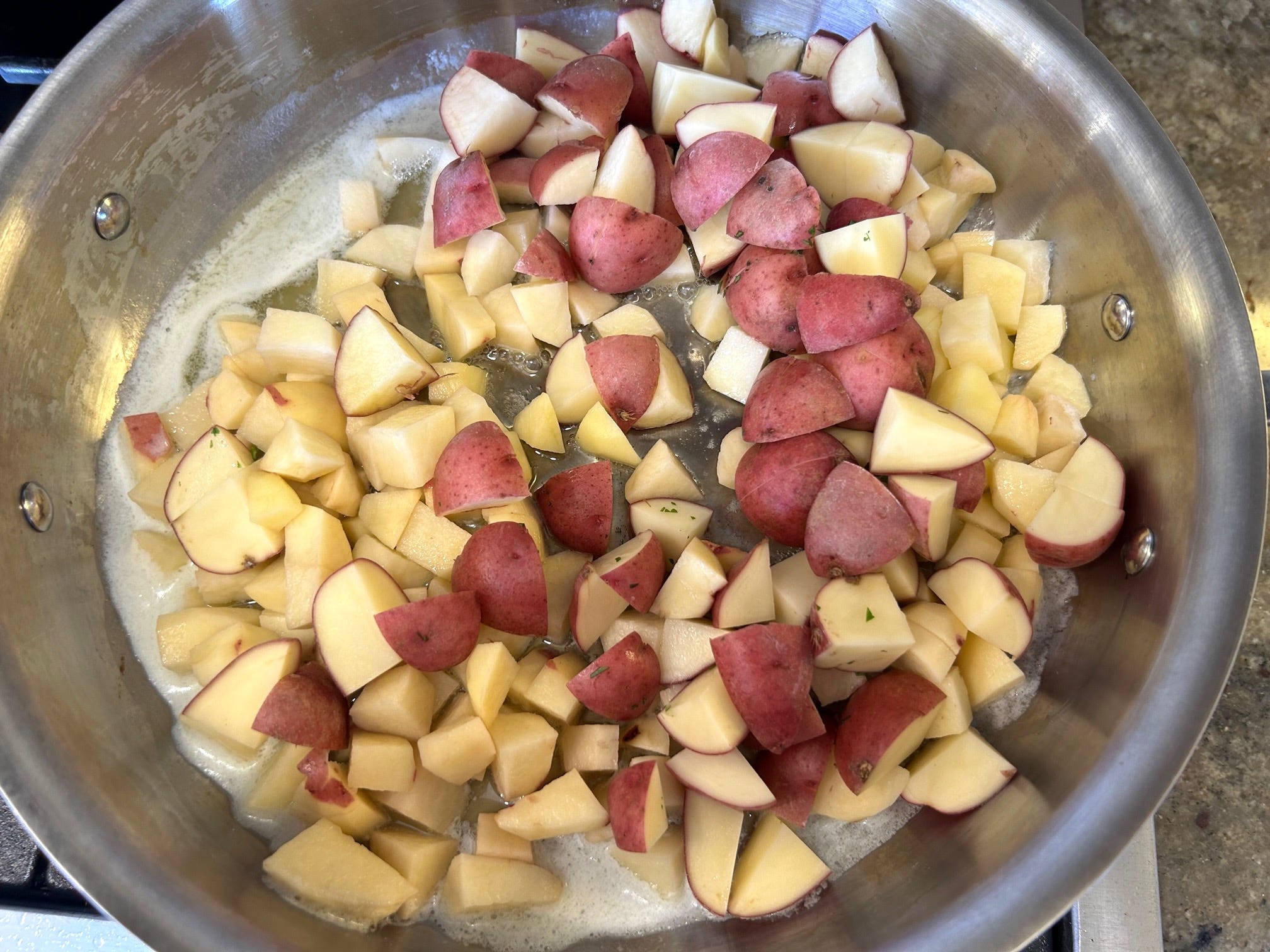 Putting potatoes in the pan Ina Garten's Hashed Brown Potatoes