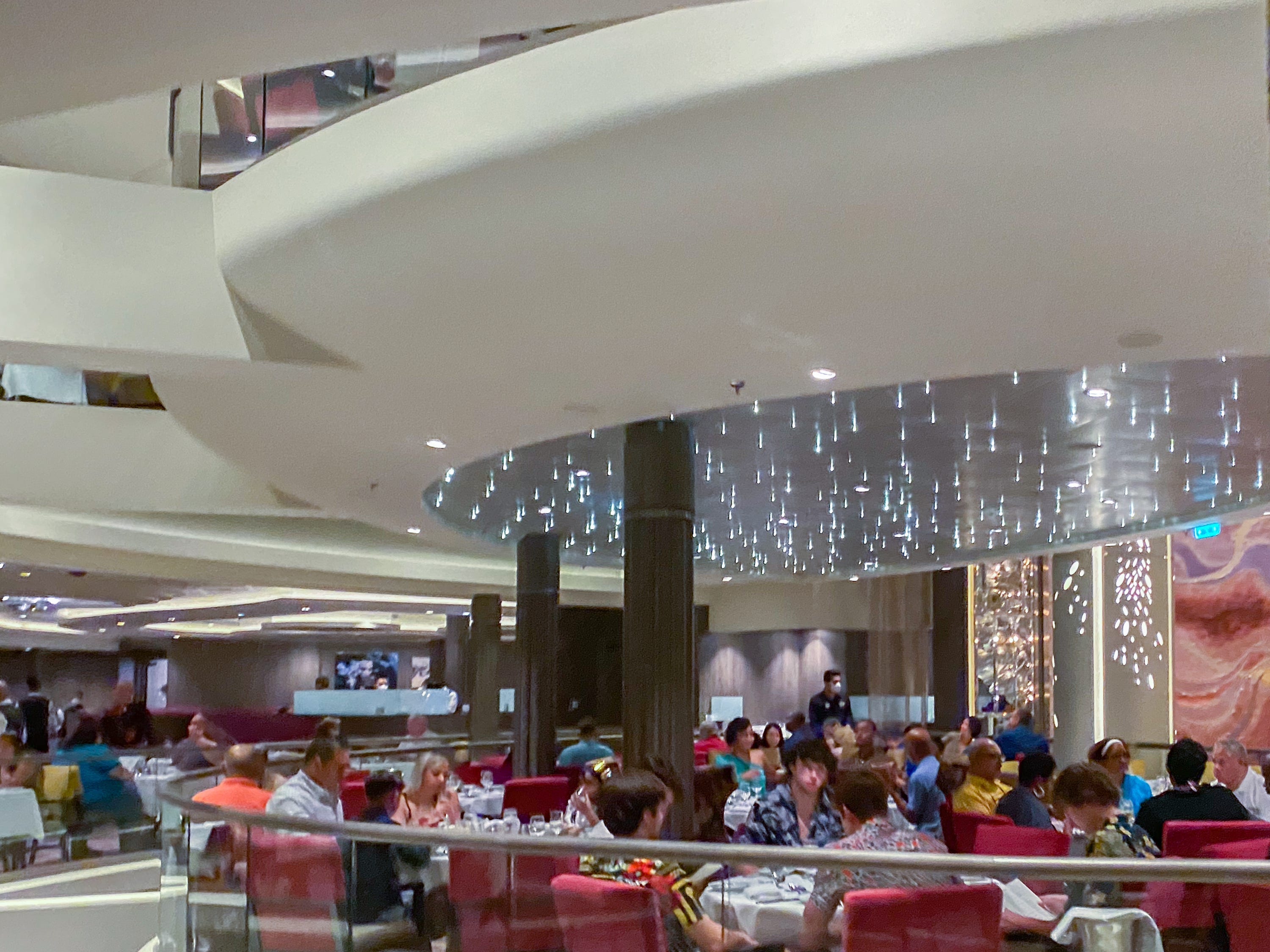 People sit in the main dining room on the world's largest cruise ship