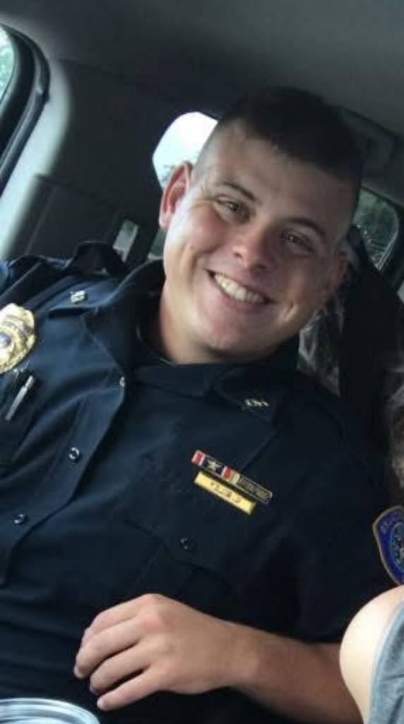 Man in police uniform smiling.