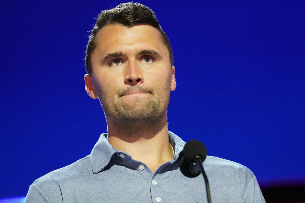 Charlie Kirk speaking on stage at the Fiserv Forum.