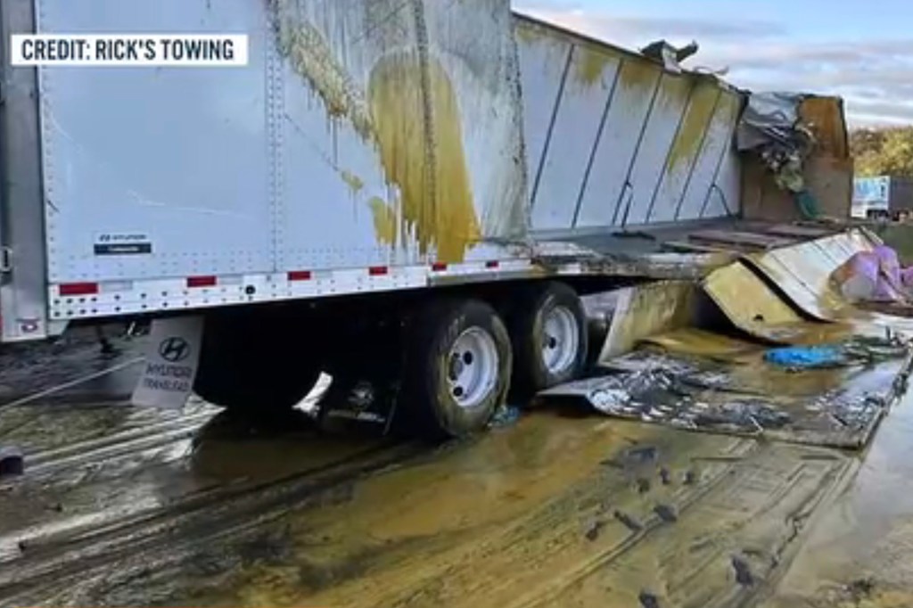Overturned semi-truck spilling applesauce onto the road.
