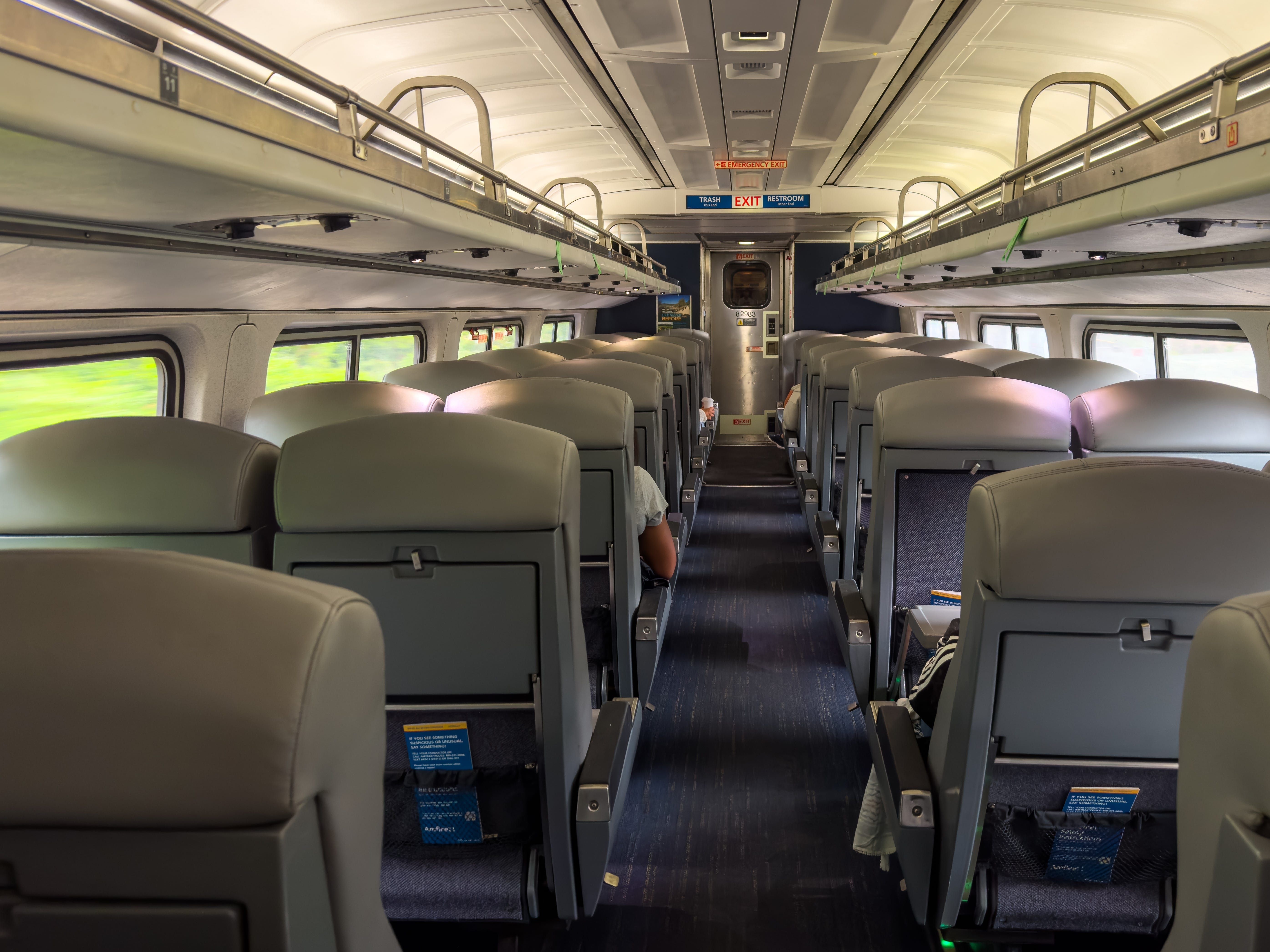 The interior of an Amtrak train with two seats in each row.