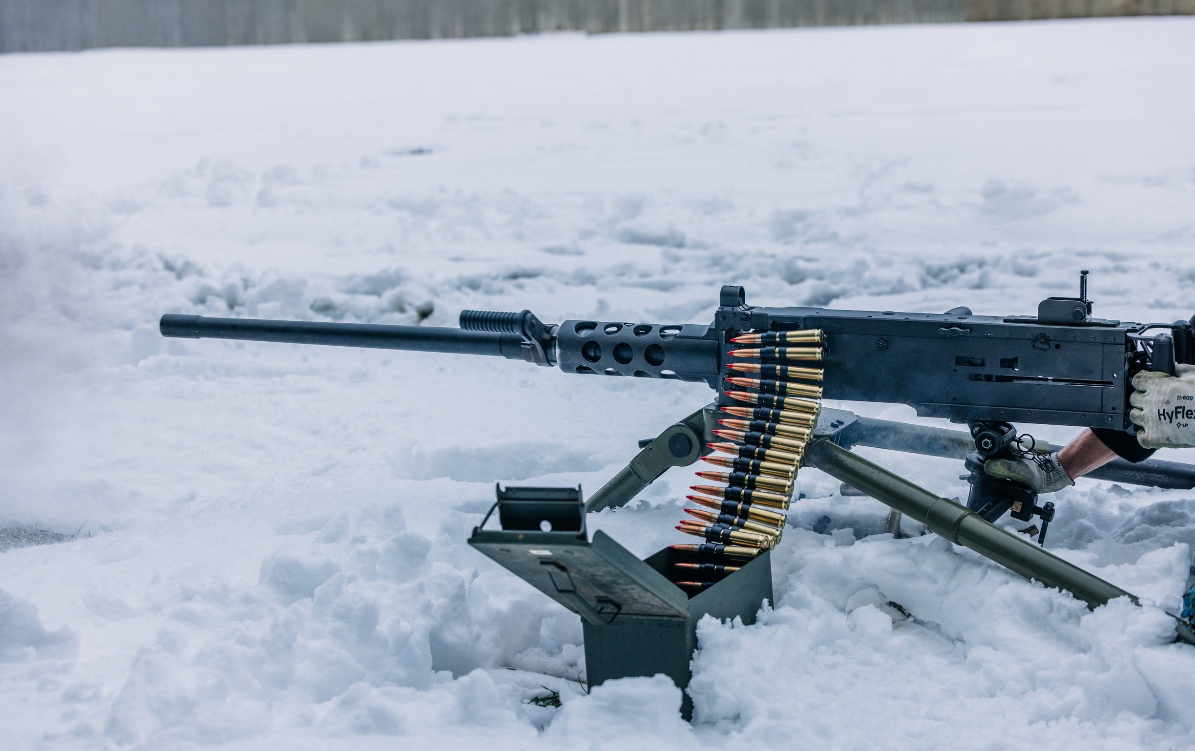 An M2 Browning is laid out on snow.