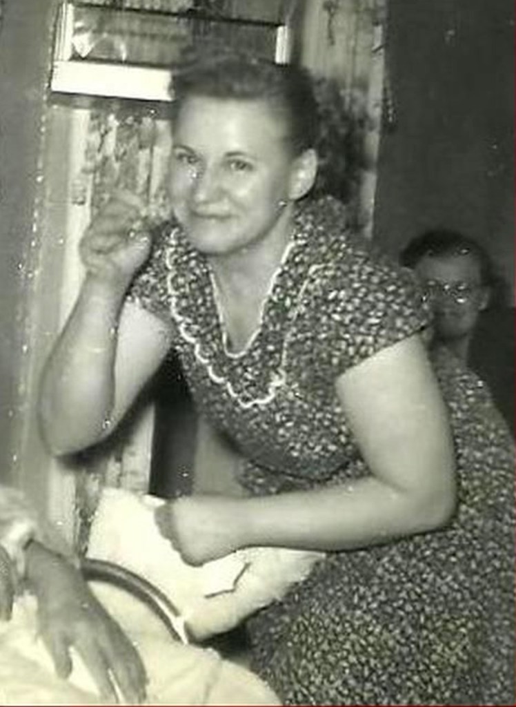 Photo of homicide victim Catherine Blackburn, 50, in a patterned dress, smiling and gesturing with her right hand.