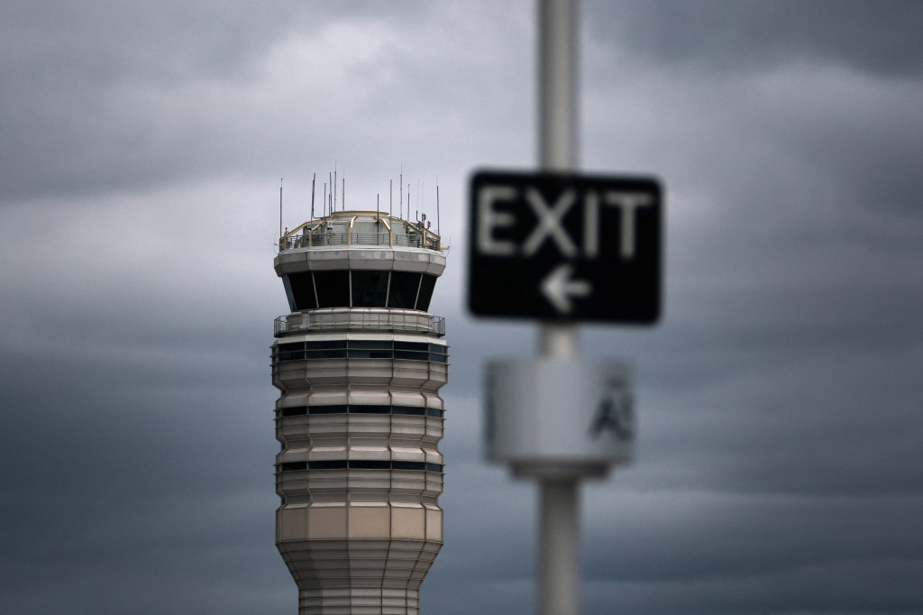 An air traffic control tower against a cloudy sky.