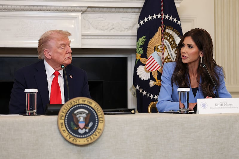 Secretary of Homeland Security Kristi Noem (R) speaks as U.S. President Donald Trump listens during a roundtable discussion in the State Dining Room of the White House on October 08, 2025 in Washington, DC. Trump’s administration held the roundtable to discuss the anti-fascist Antifa movement after signing an executive order designating it as a “domestic terrorist organization”.
