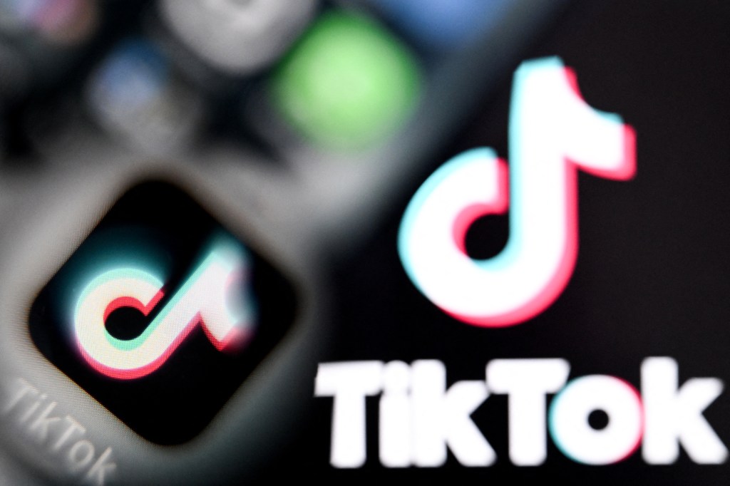 TikTok logos displayed on a smartphone and laptop screen.