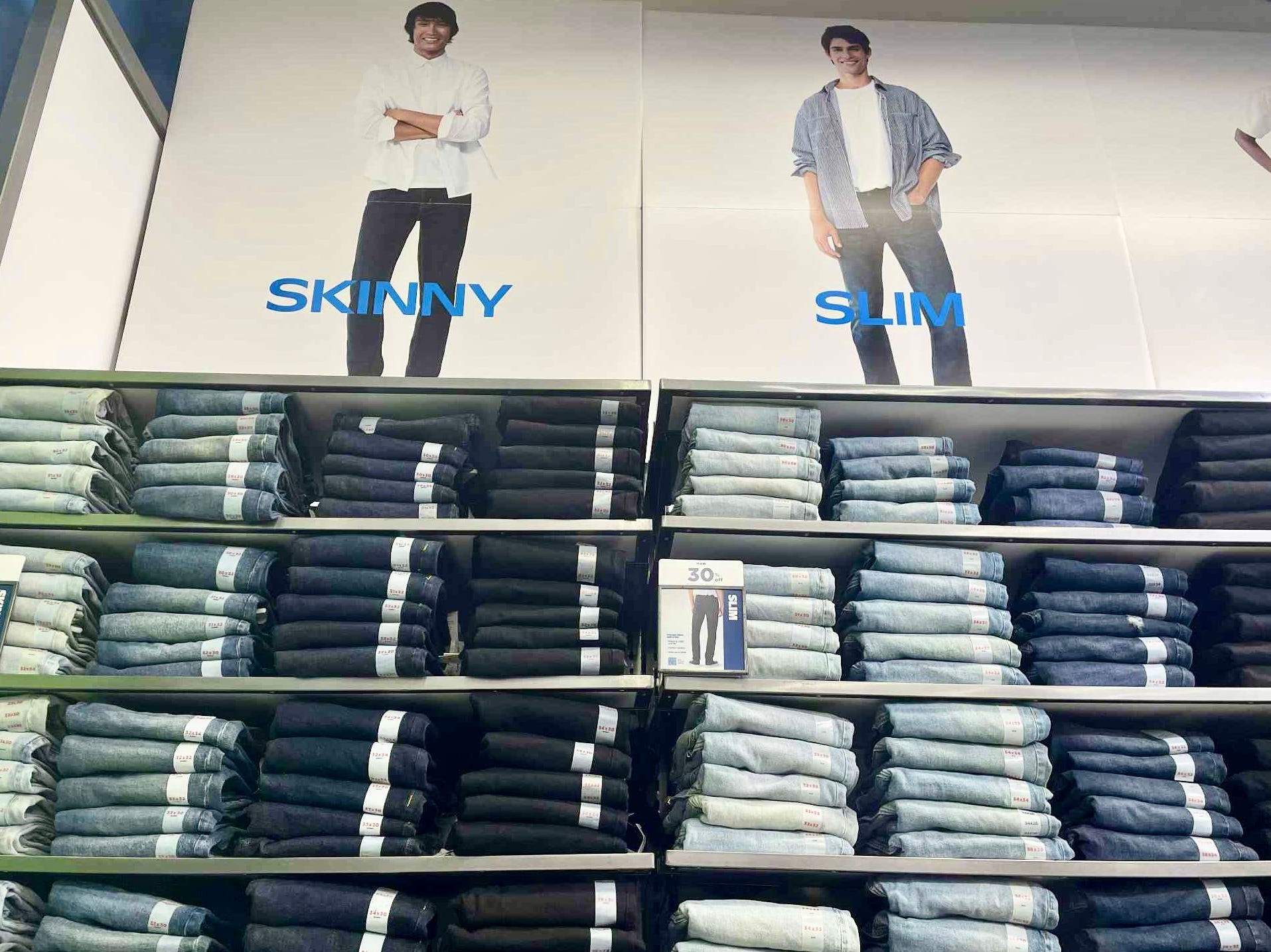 A wall of shelves with rows of folded jeans.