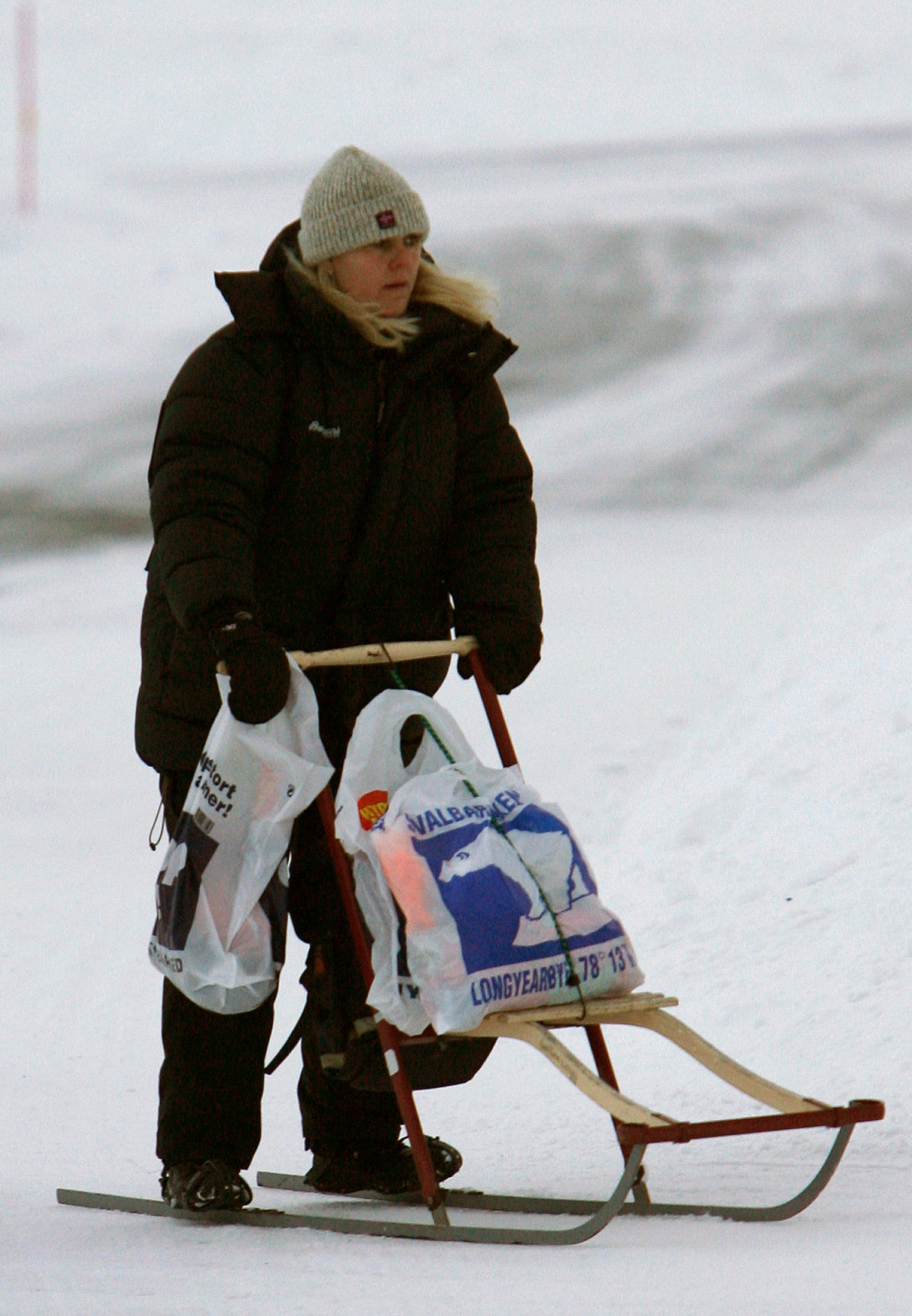 A local resident rides a push sled home with her shopping in Longyearbyen February 25, 2008.