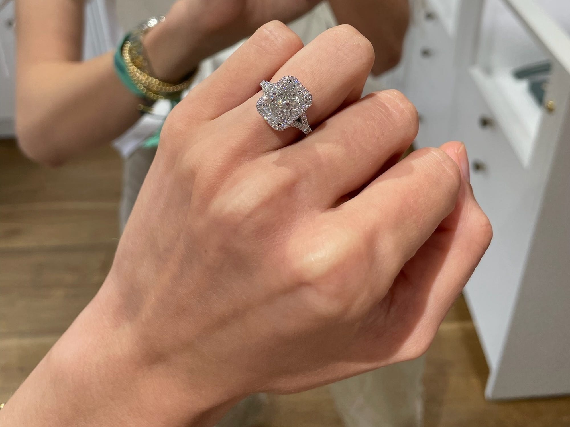 A large emerald cut engagement ring with diamonds on the band.