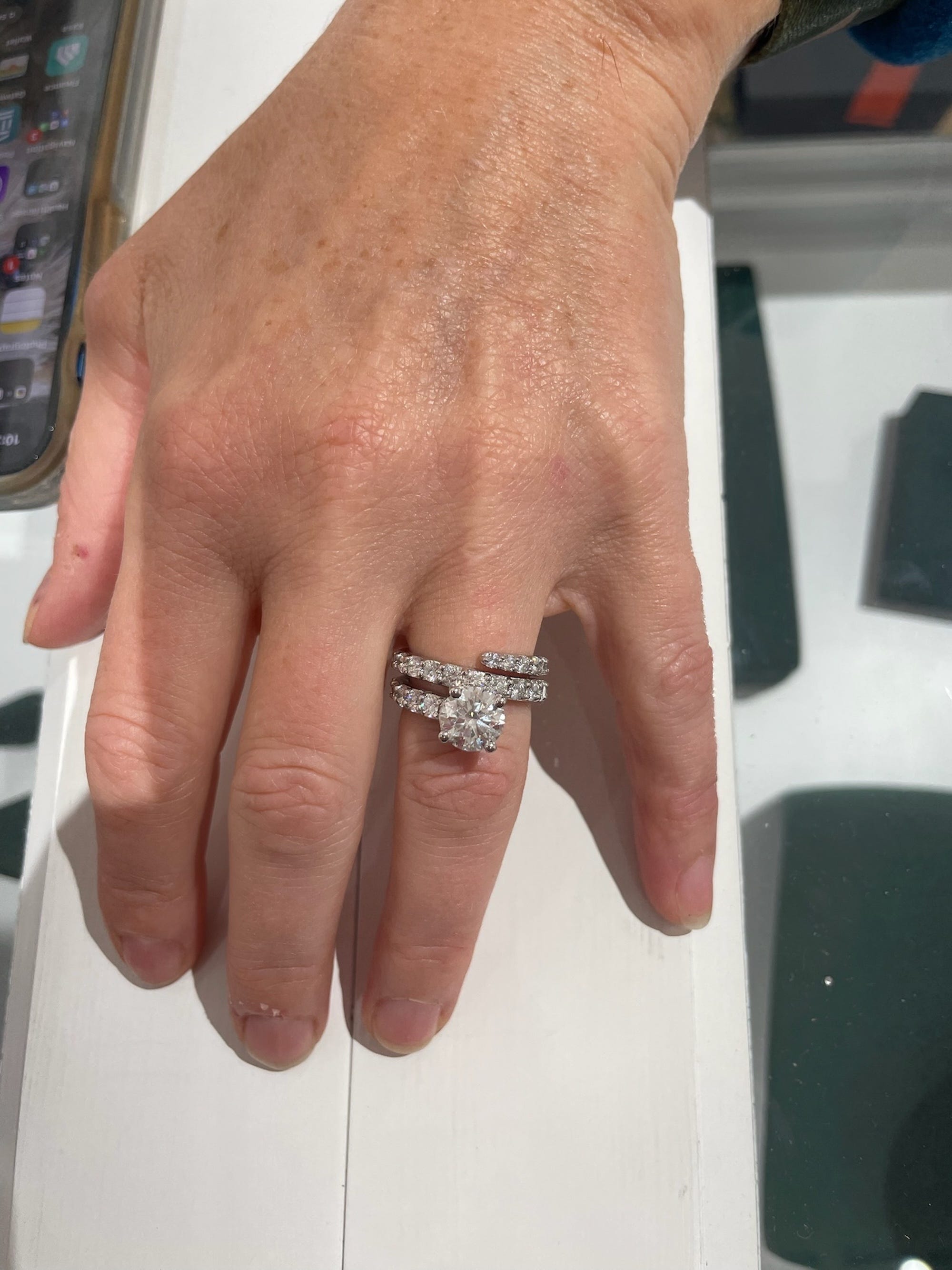 An engagement ring with a diamond band that wraps around the finger three times on a hand.