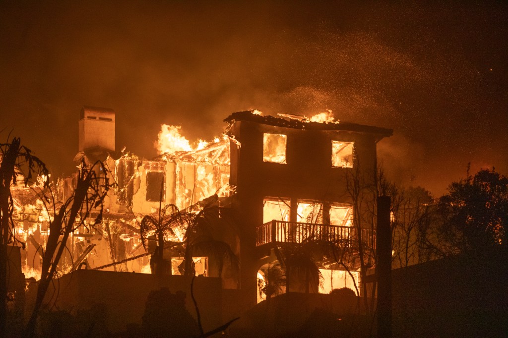 A multi-story house fully engulfed in flames during the Palisades Fire in Los Angeles, California.