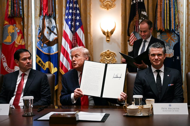 US President Donald Trump (C) holds up signing documents recognizing days honoring Leif Erikson and Christopher Columbus while he speaks during a cabinet meeting, alongside Secretary of State Marco Rubio (L) and Secretary of Defense Pete Hegseth (R), in the Cabinet Room of the White House in Washington, DC, on October 9, 2025. Trump said Thursday he would try to go to Egypt for the signing of a Gaza ceasefire and hostage release deal between Israel and Hamas. (Photo by Jim WATSON / AFP) (Photo by JIM WATSON/AFP via Getty Images)