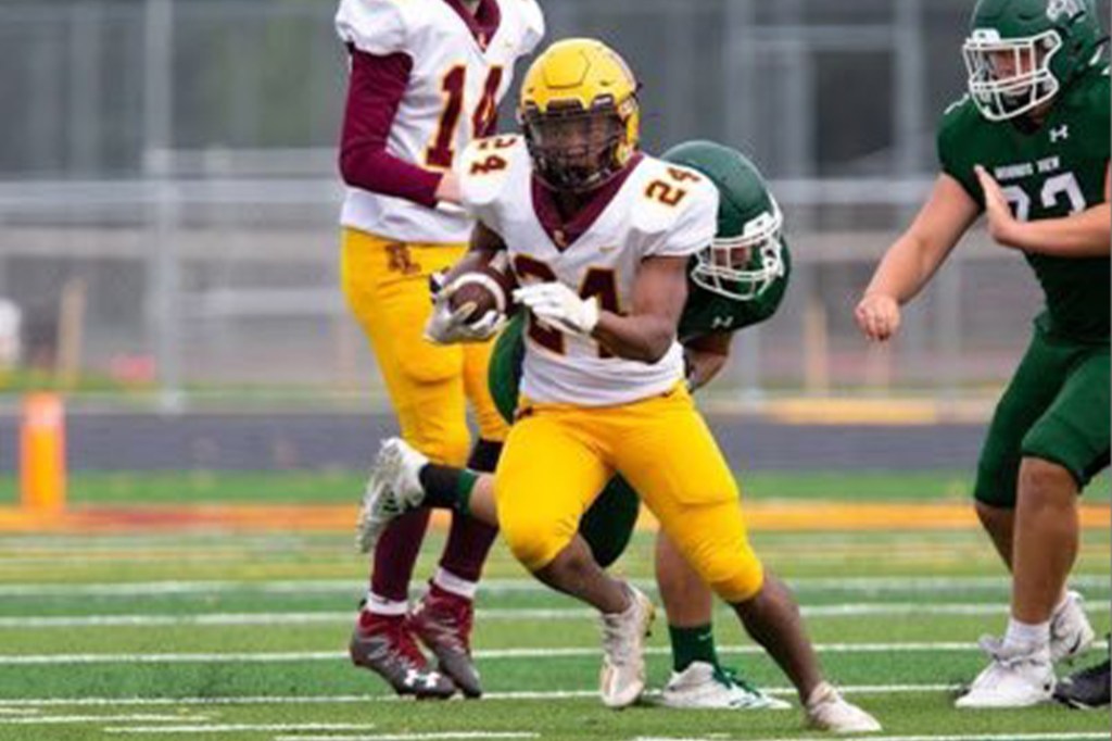 Kelvin Luebke, number 24, running with the football during a game.