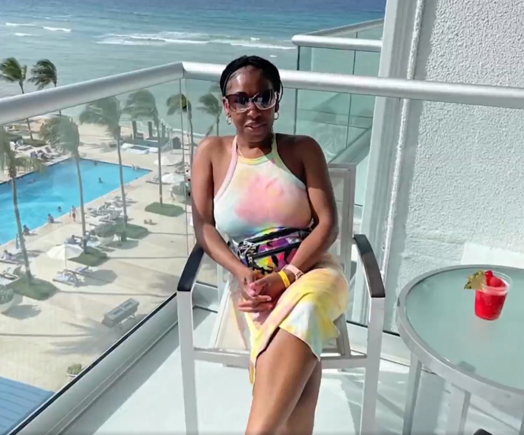 Victim Carlene Williams sits on a balcony overlooking a pool and ocean.