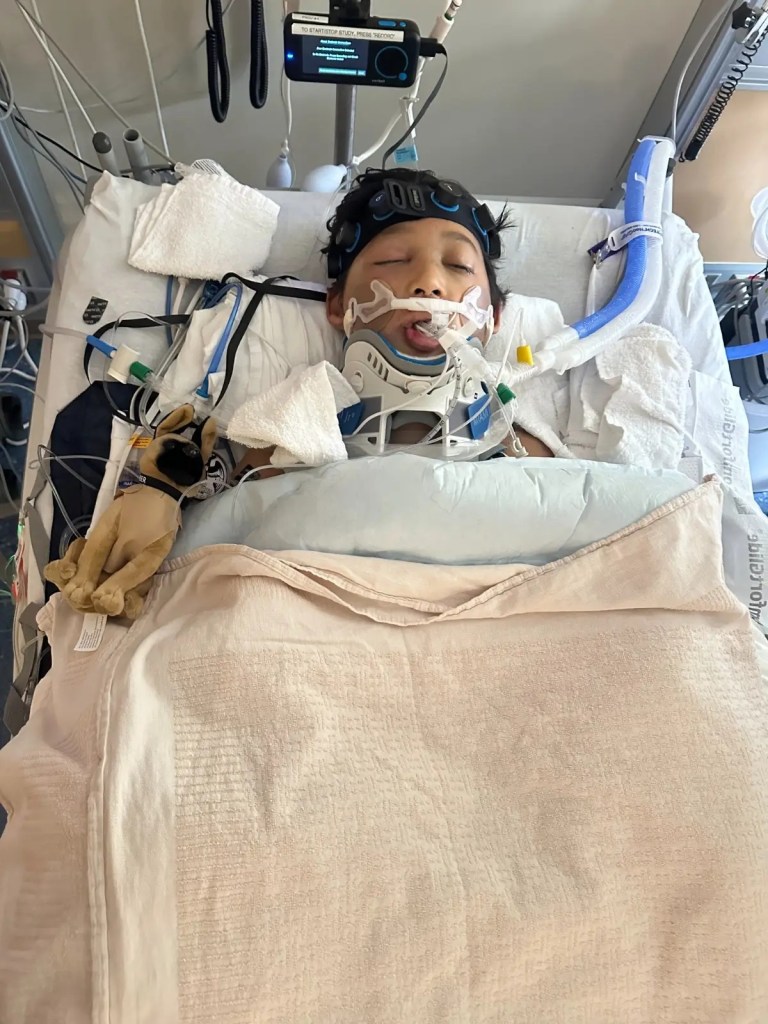 A critically injured 12-year-old boy in a hospital bed with medical equipment.