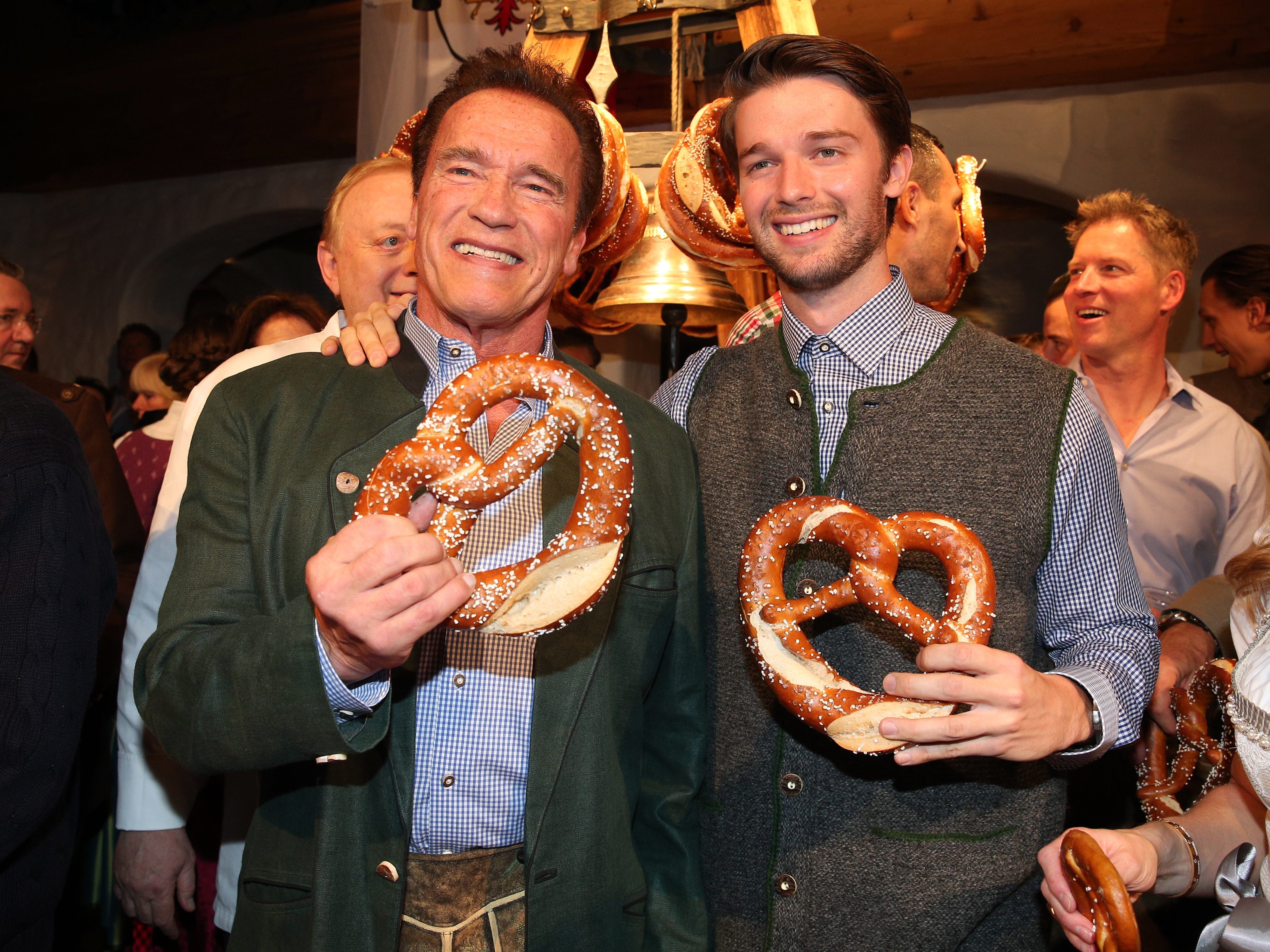 Arnold and Patrick Schwarzenegger holding pretzels