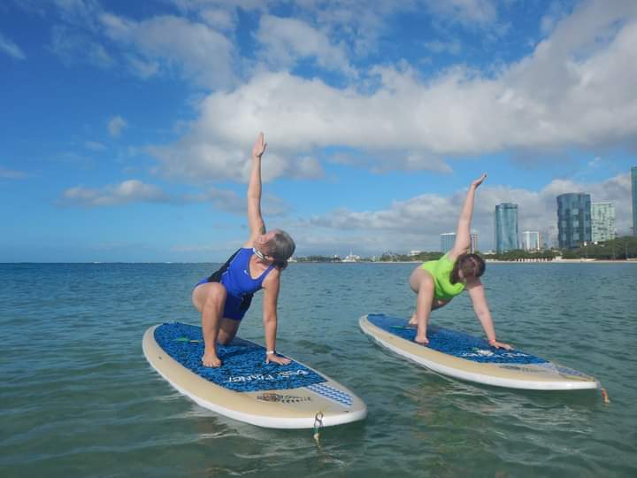 The author and her daughter participate in paddle board yoga.