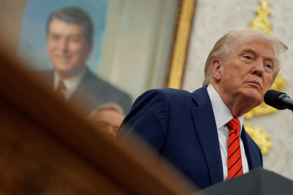 Trump in front of a portrait of reagan