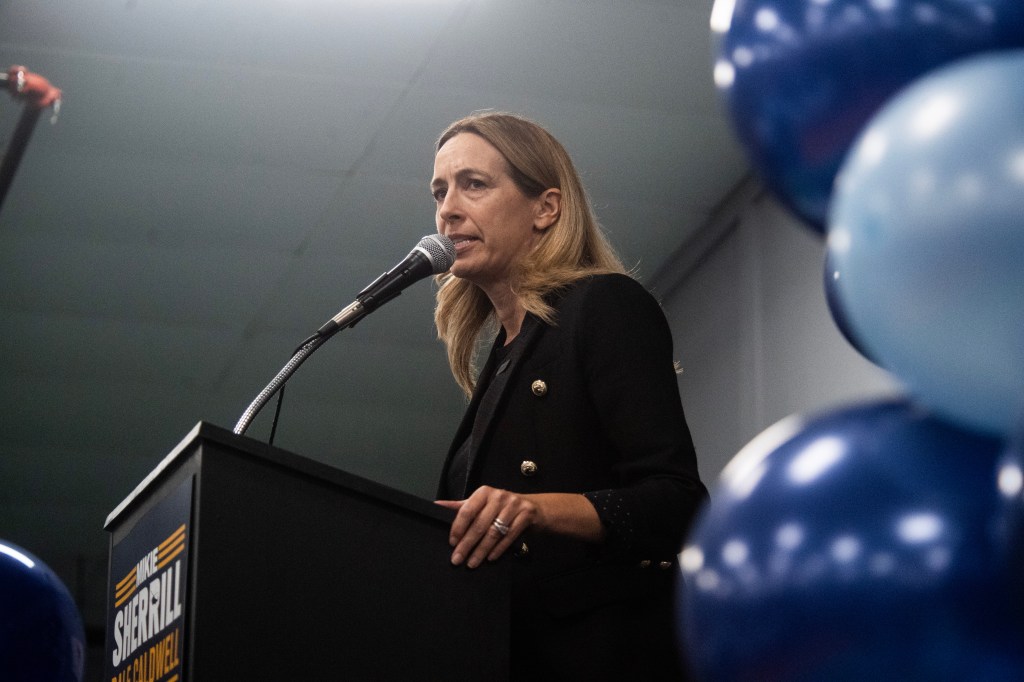 Mikie Sherrill at a podium with a microphone, addressing a crowd.