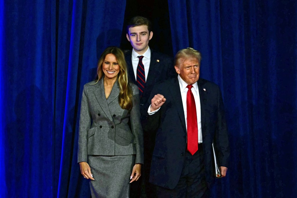 Donald Trump, Melania Trump, and Barron Trump walk onto a stage.