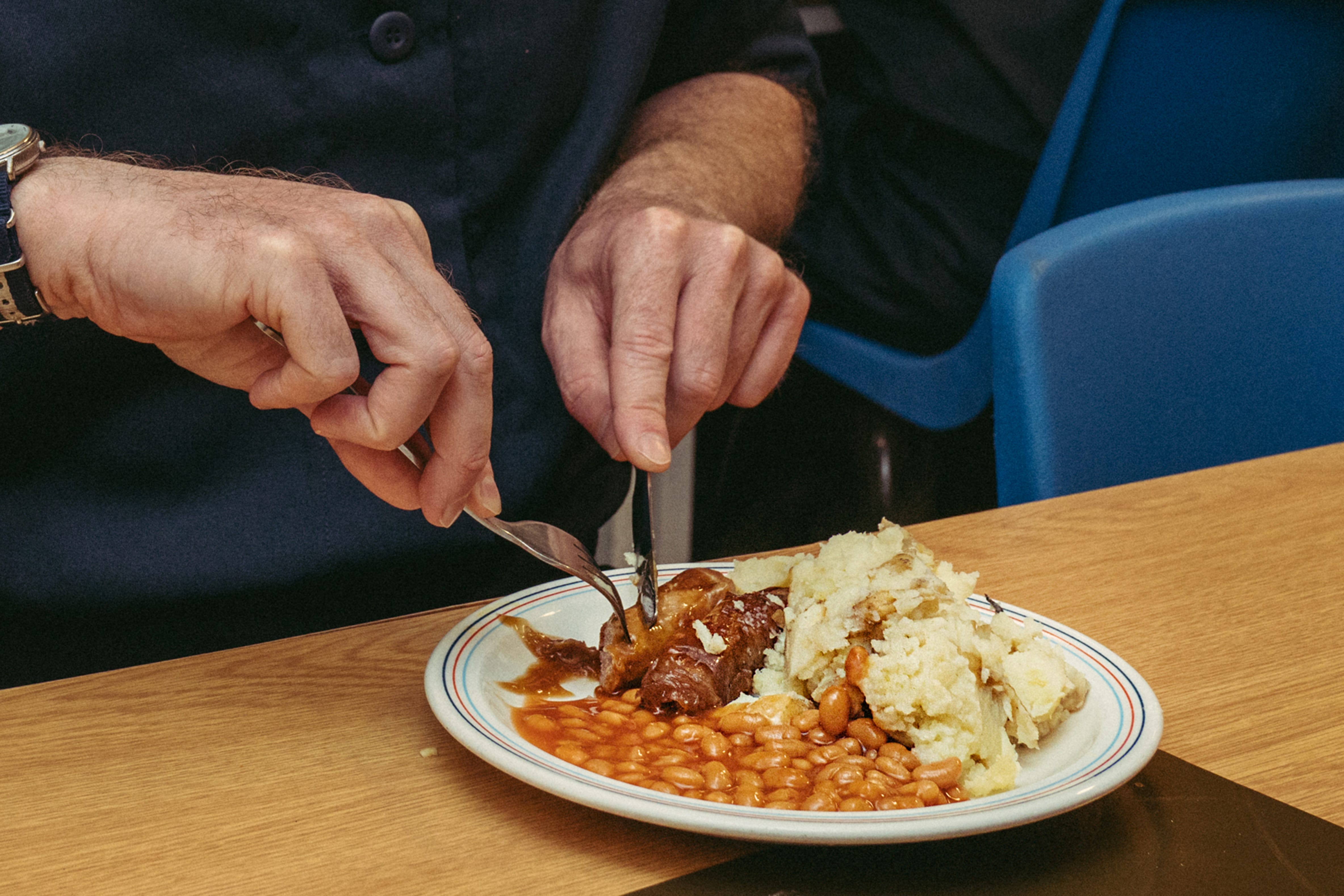 A Royal Navy officer eats his lunch in the junior rates galley.