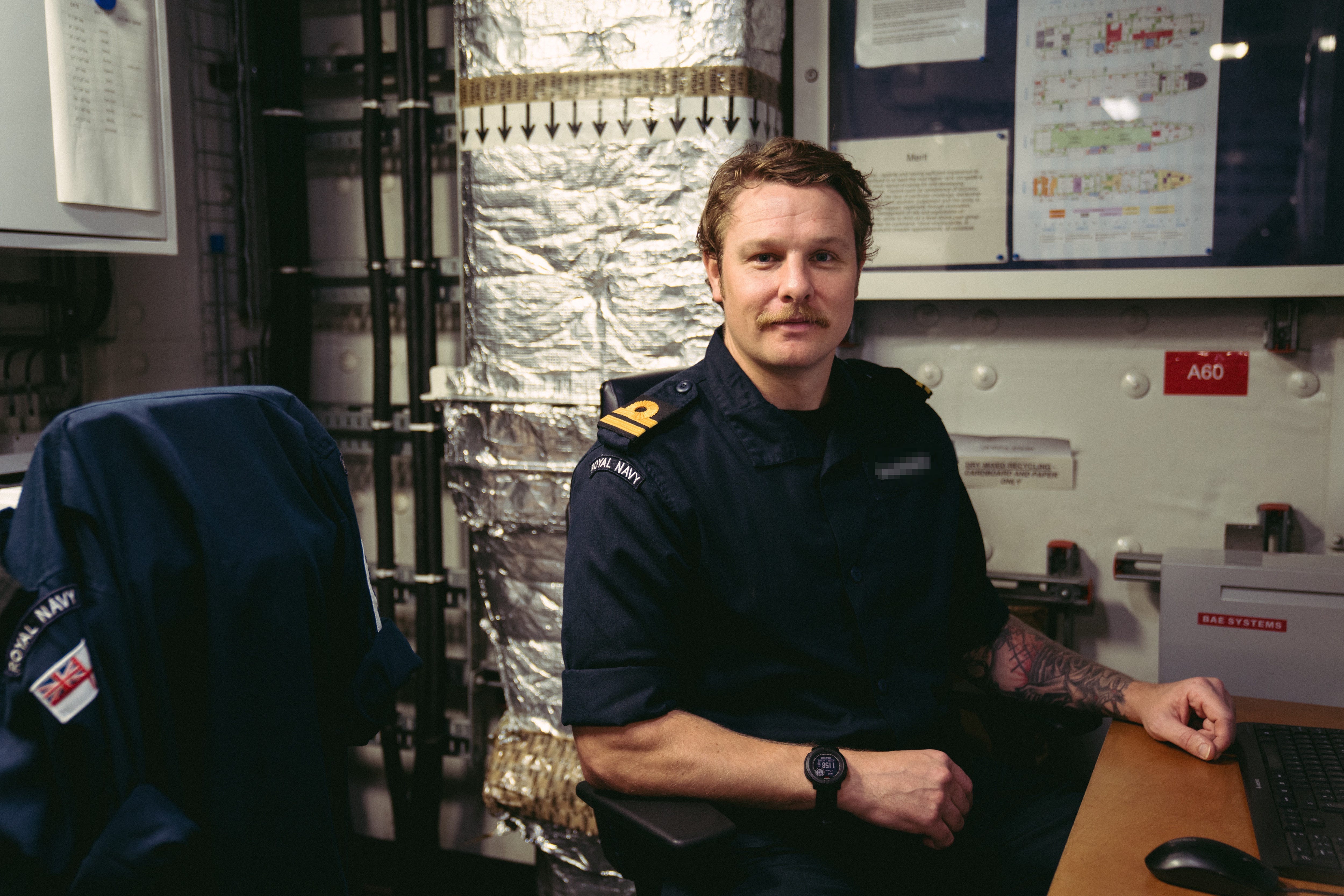 Lt. Dickie poses for a photo in an office chair on the Prince of Wales.