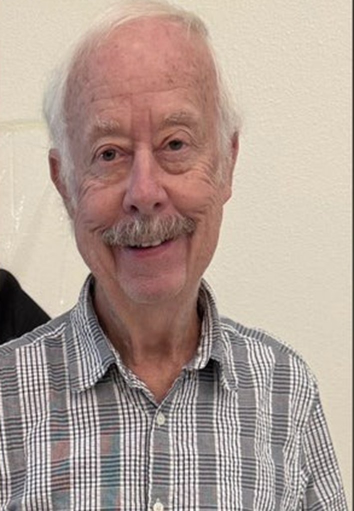 Headshot of Gene smiling.