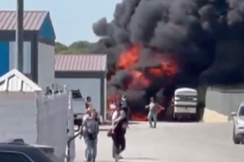 People running from a large fire and smoke plume.