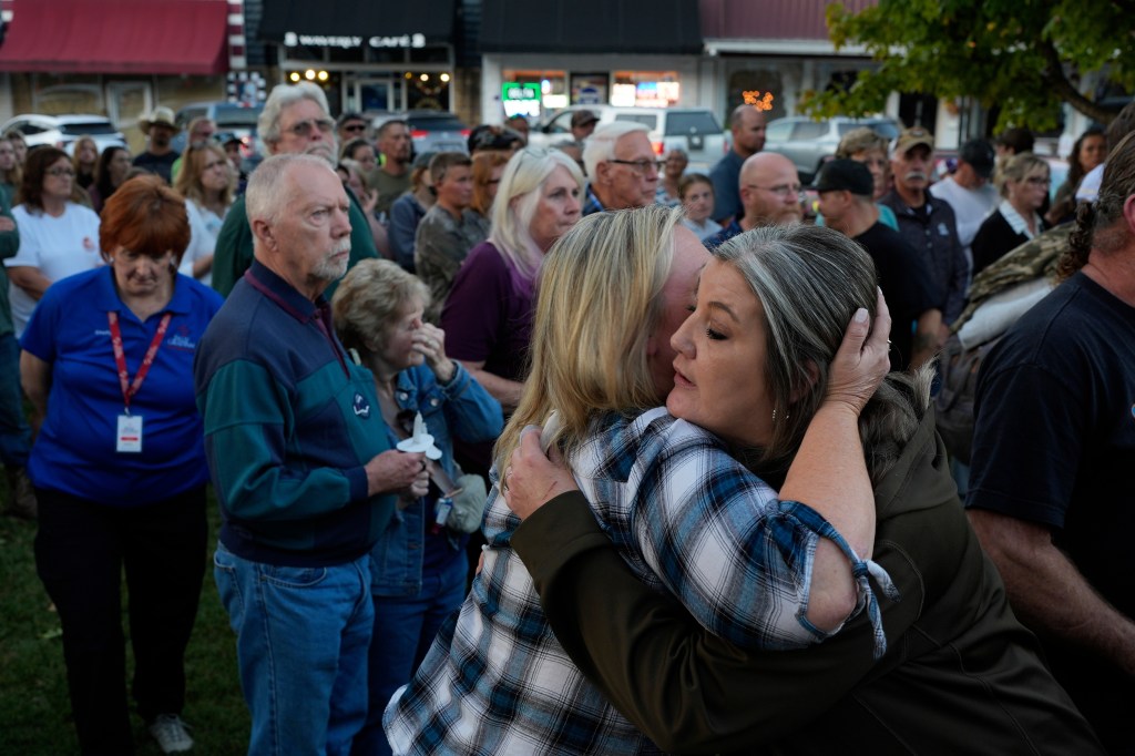 Christina Williams, right, hugs Tracy Cook during a candlelight vigil honoring victims of a blast at an explosives plant in Waverly, Tenn.