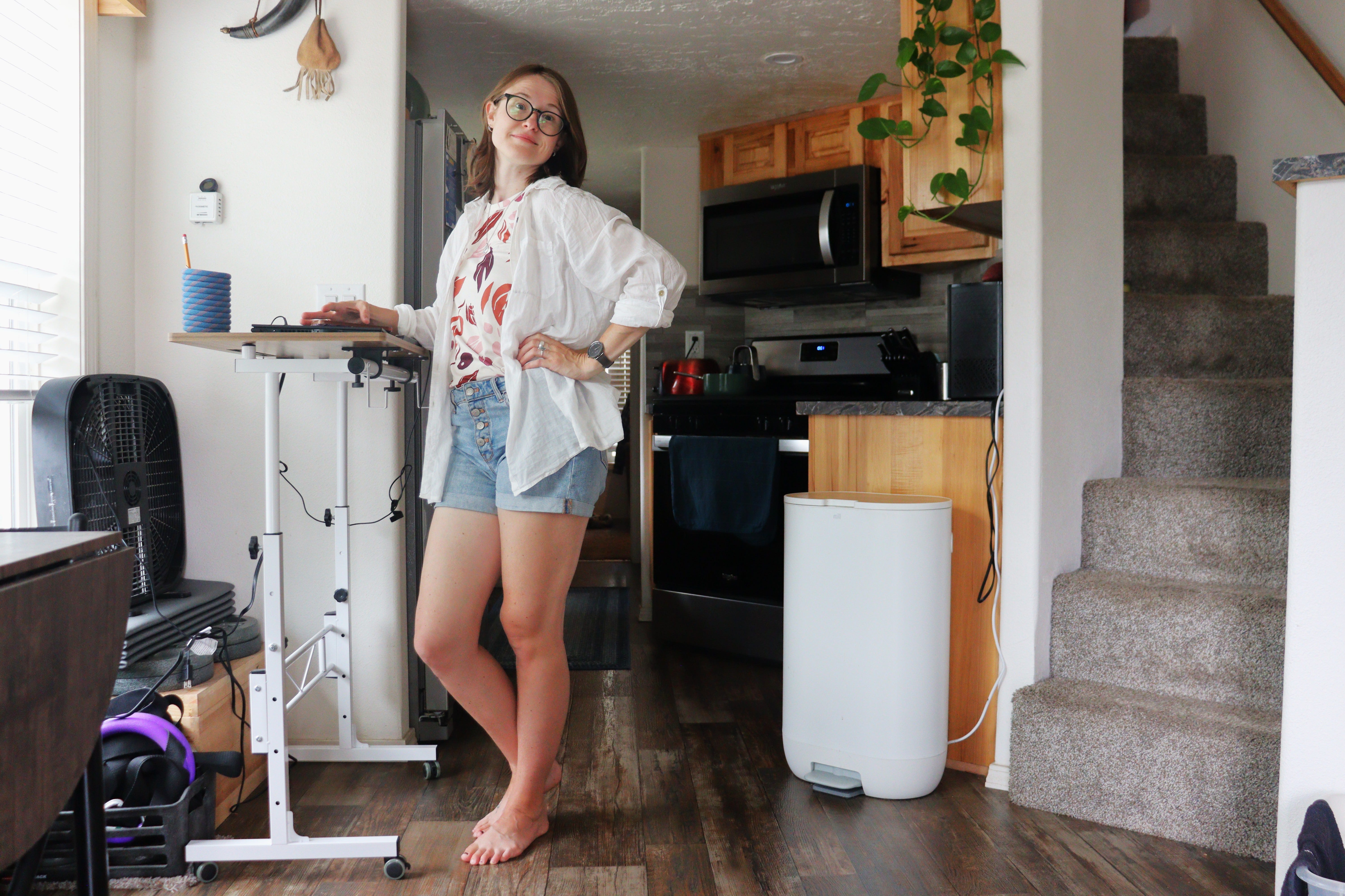 Author Amber McDaniel posing at standing desk in kitchen of tiny home