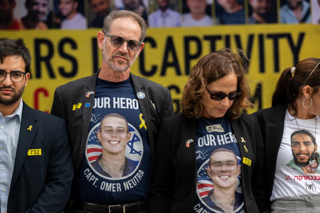 Ronen and Orna Neutra, wearing shirts with an image of their son Omer Neutra, attend a vigil at the Kennedy Center.