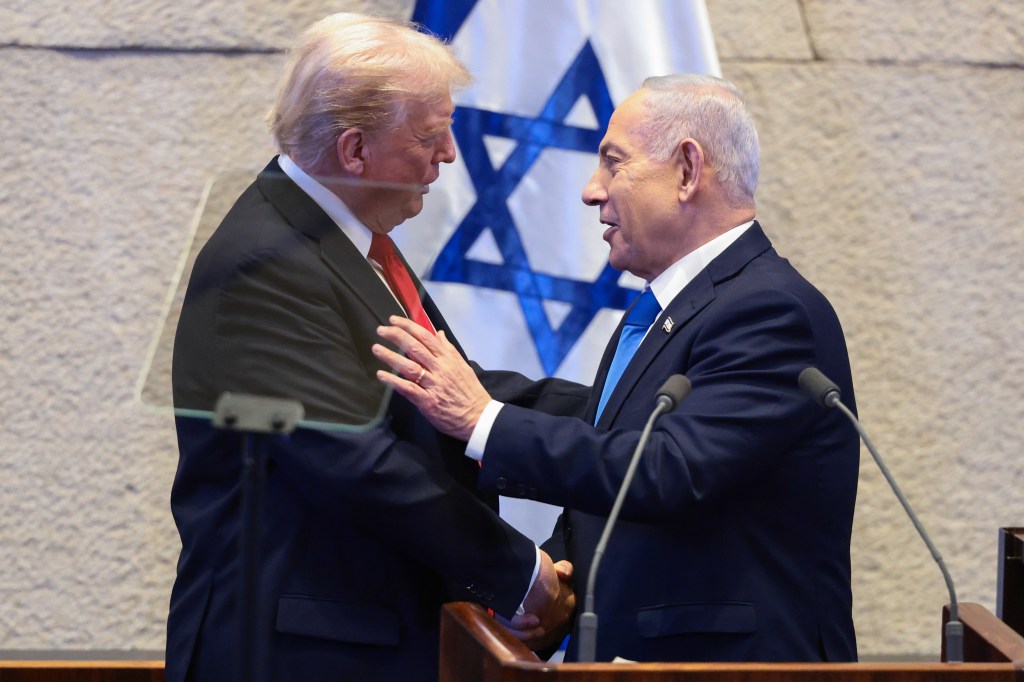 President Trump and Prime Minister Benjamin Netanyahu shake hands in front of an Israeli flag.