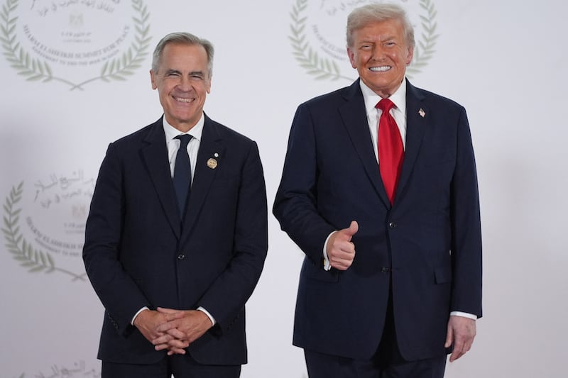 Canadian Prime Minister Mark Carney poses for a picture with President Donald Trump ahead of jokingly correcting him later at the event for mistakenly calling him "president" during a summit on Gaza in Sharm el-Sheikh on October 13, 2025.