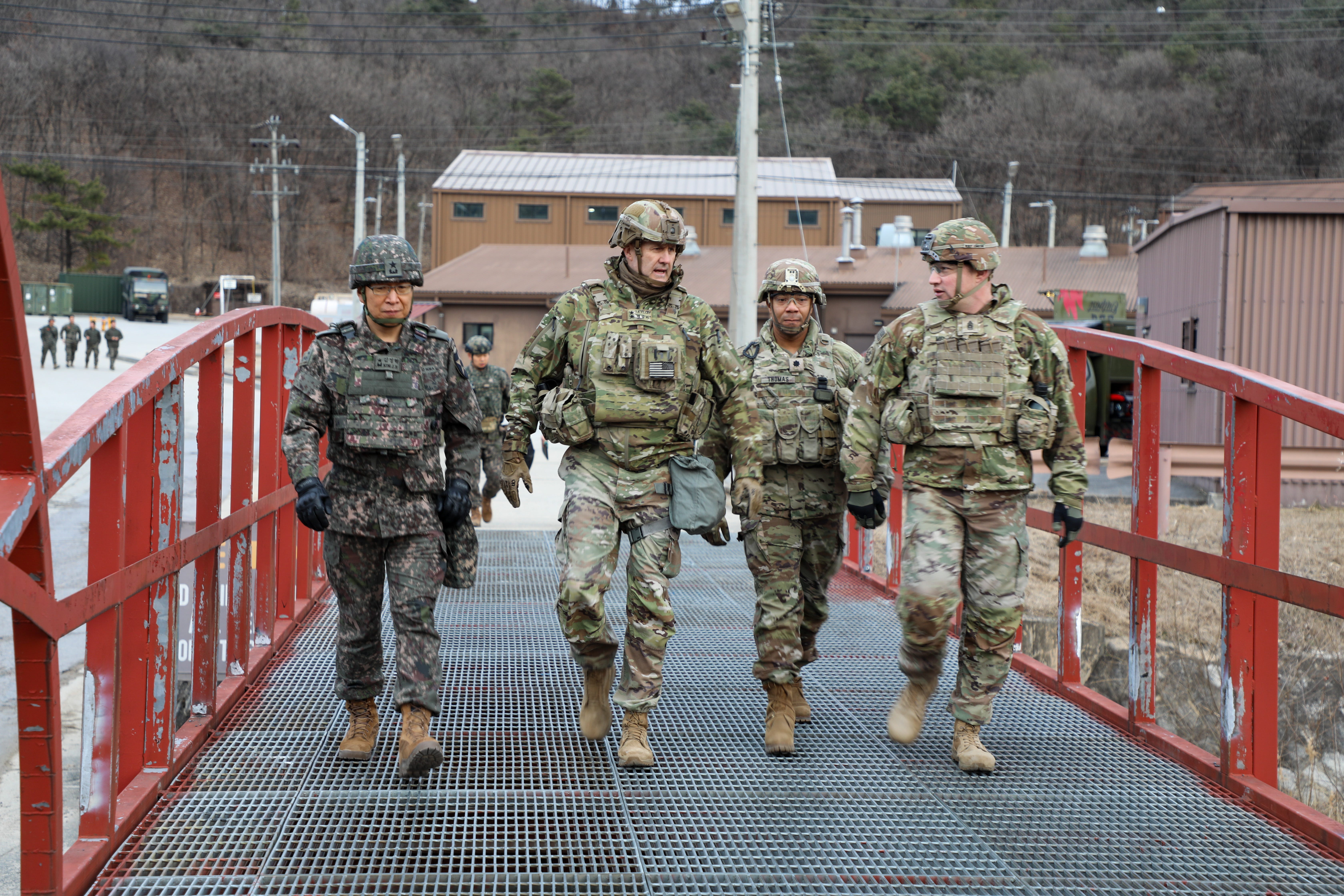 An American Army general walks alongside US soldiers and partner forces.