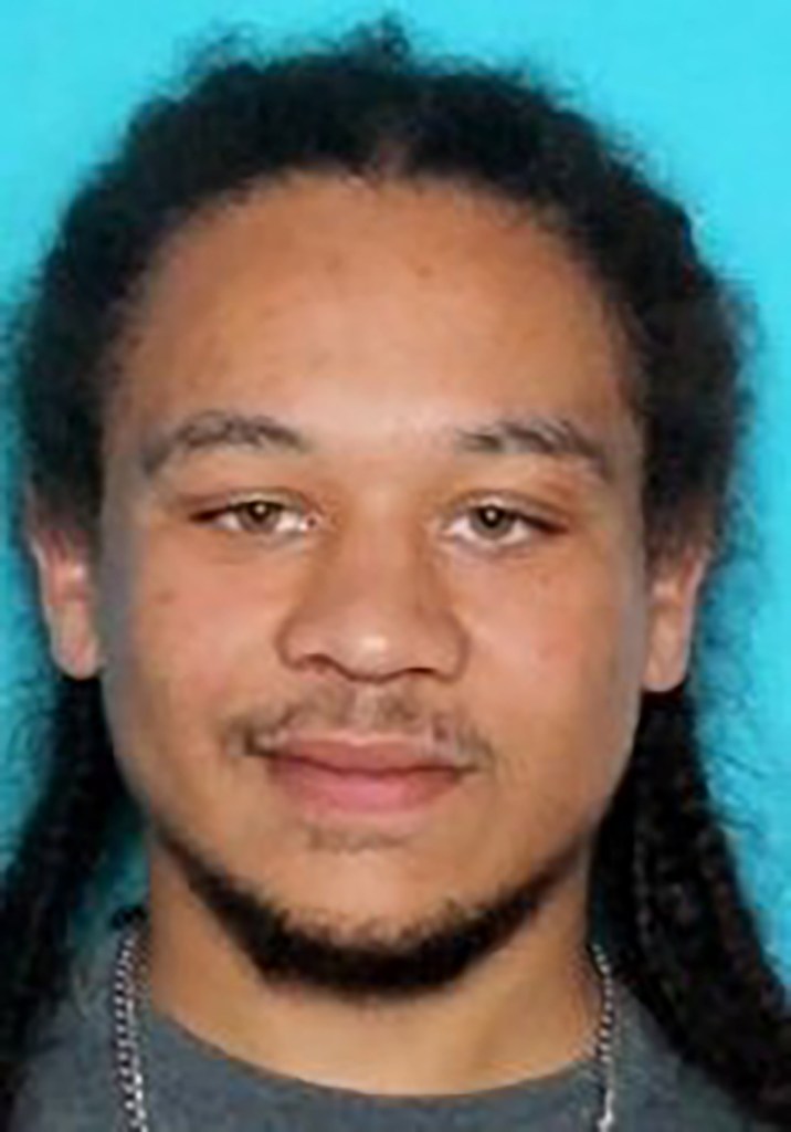 Tristan Bush, a light-skinned Black man with dreadlocks, a mustache, and a beard, looks directly at the camera.