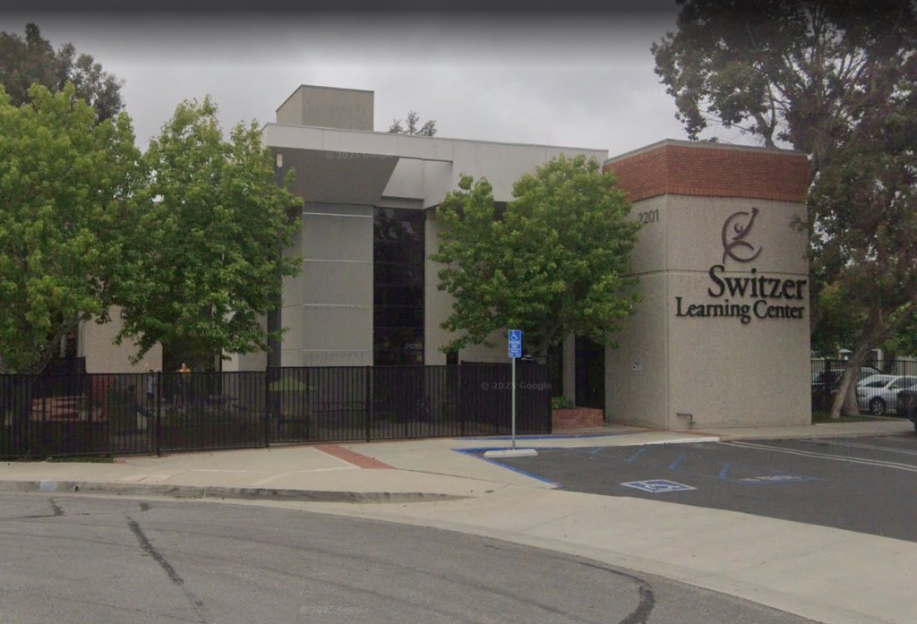 Switzer Learning Center building with black fencing and surrounding trees.