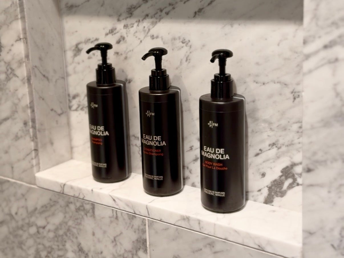 Bottles of shampoo, conditioner, and body wash on a shelf in the shower.