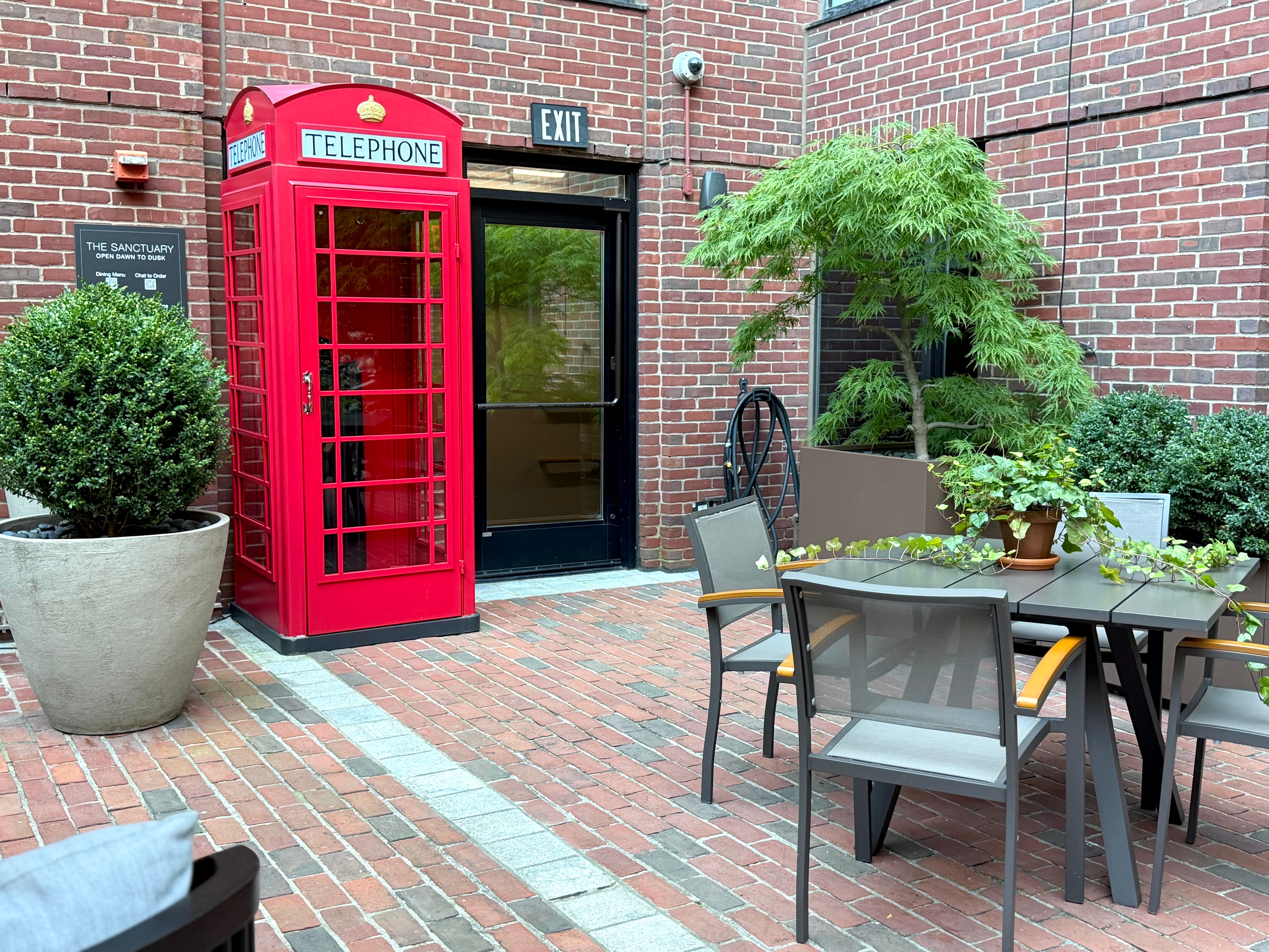The Sanctuary at the Four Seasons, with tables, chairs, and a red telephone booth.