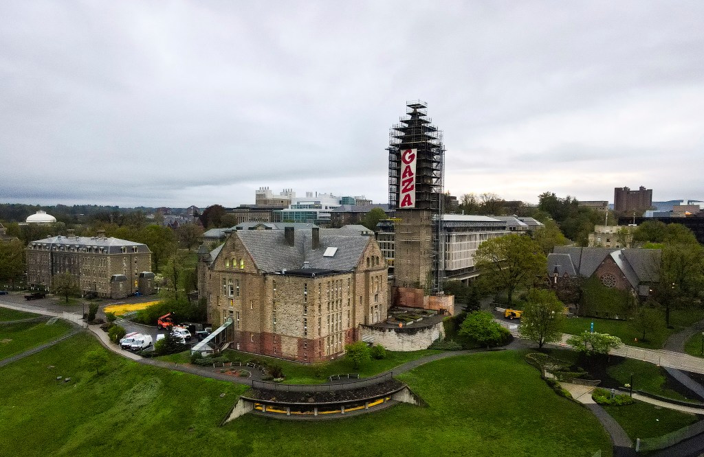 A pro-Palestinian banner that reads, GAZA, hangs from scaffolding on McGraw Tower at Cornell University.