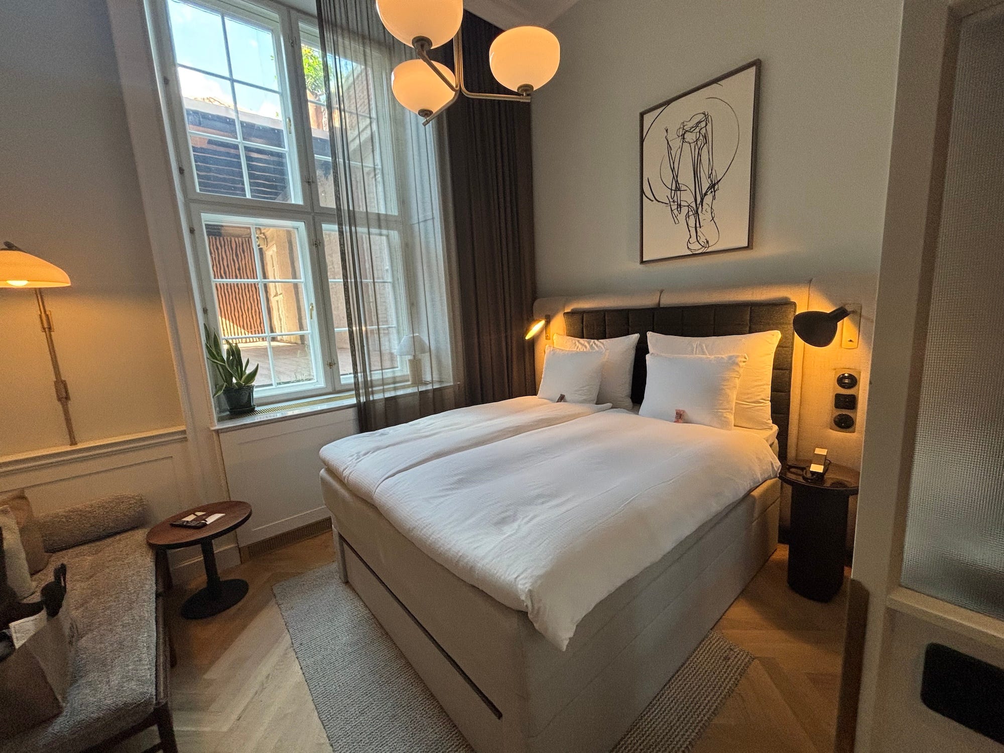 A bedroom in a hotel in Copenhagen with neutral colors.
