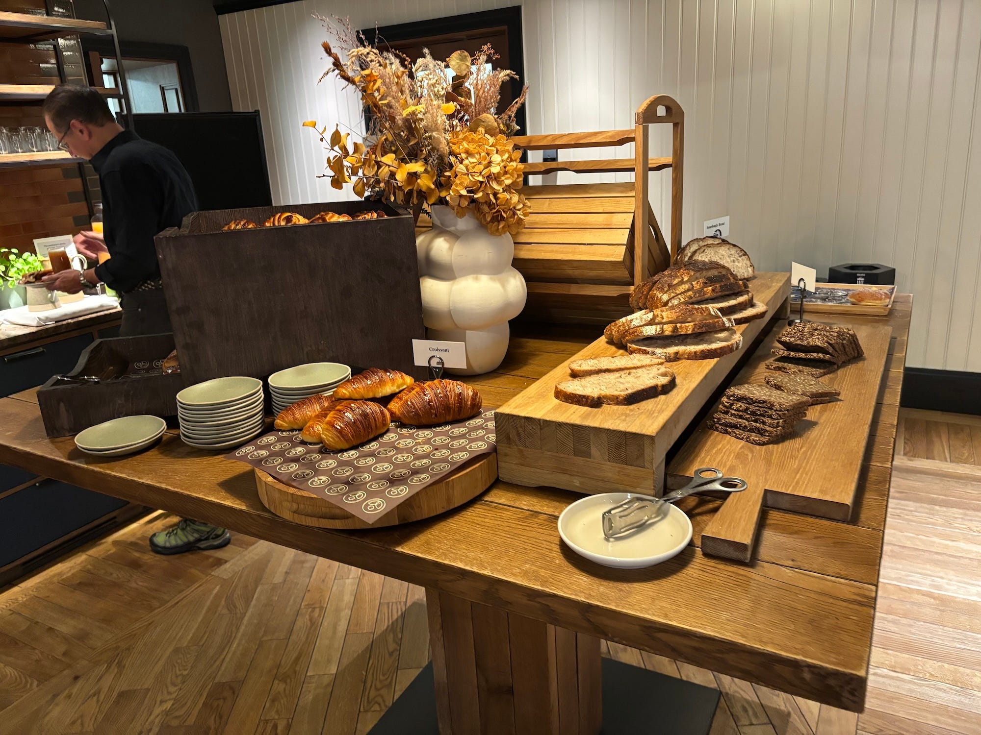 A display of bread and pastries at a breakfast buffet.