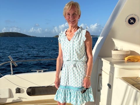 A woman wearing a blue and white dress on a yacht.
