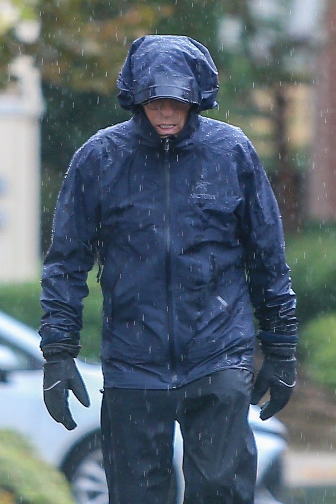 G. Scott Romney walks in the rain near his home.
