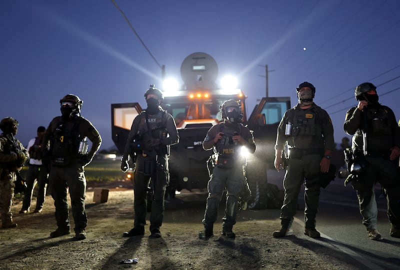 CAMARILLO, CALIFORNIA - JULY 10: Federal agents block people protesting an ICE immigration raid at a nearby licensed cannabis farm on July 10, 2025 near Camarillo, California. Protestors stood off with federal agents for hours outside the farm in the farmworker community in Ventura County. A Los Angeles federal judge is set to rule Friday on a temporary restraining order which would restrict area immigration enforcement operations. (Photo by Mario Tama/Getty Images)