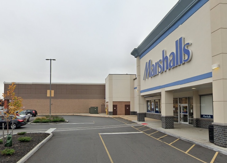 Exterior of a Marshalls store with a parking lot and another building in the background.