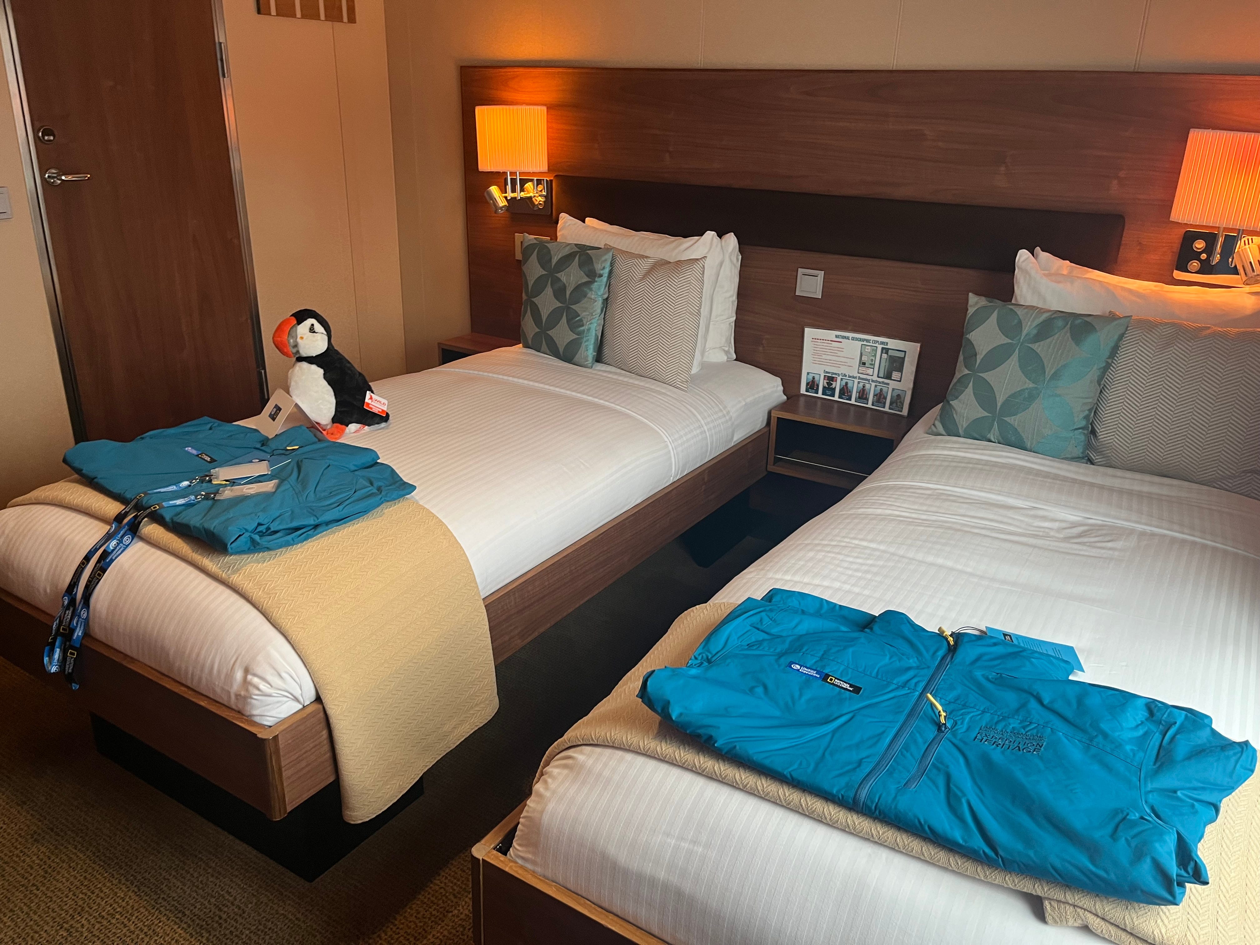 Parkas, stuffed penguin, on bed on cruise